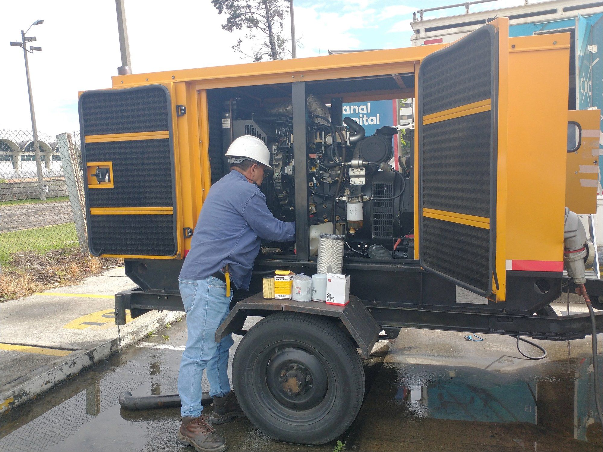 Técnico realizando mantenimiento a una planta eléctrica amarilla