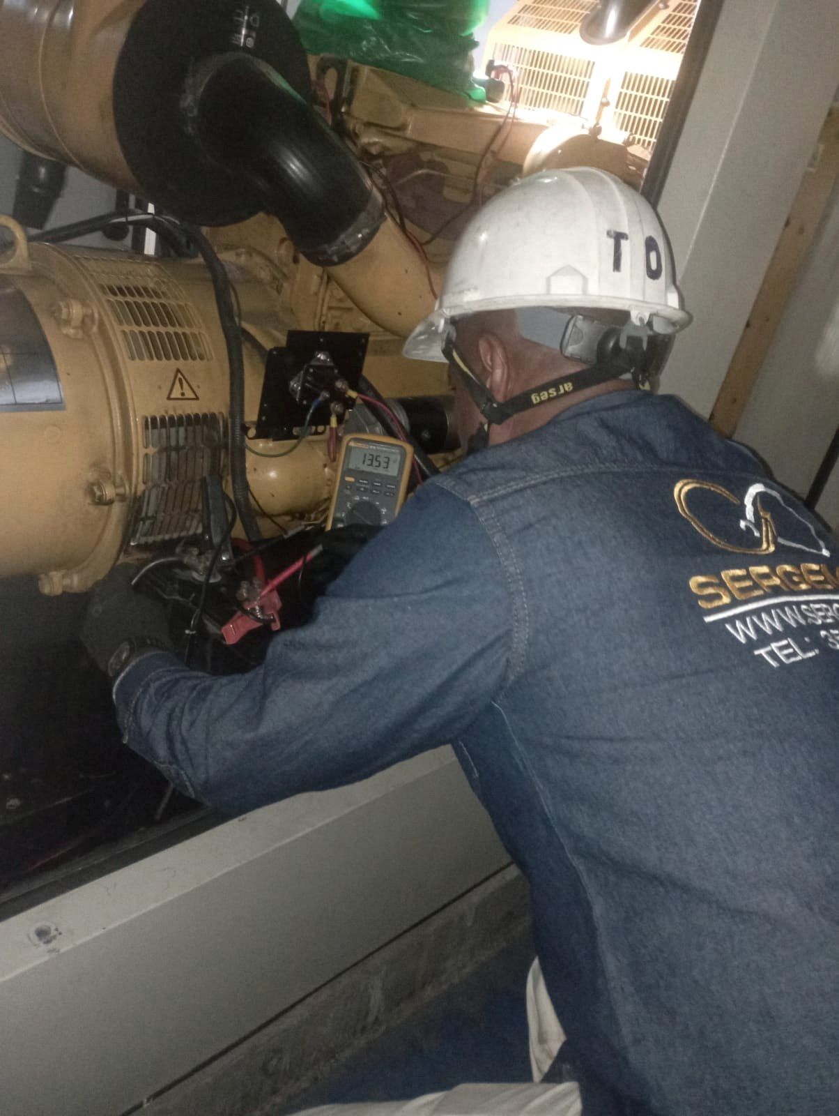 Técnico de SERGEMAQ revisando el motor de un generador