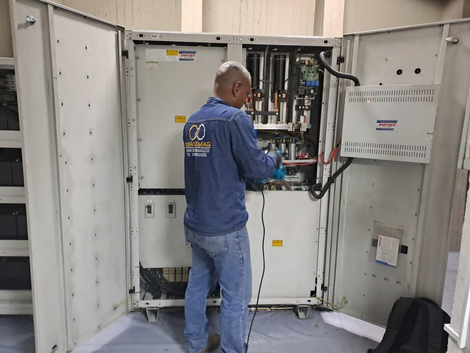 Técnico trabajando en el gabinete de una UPS industrial