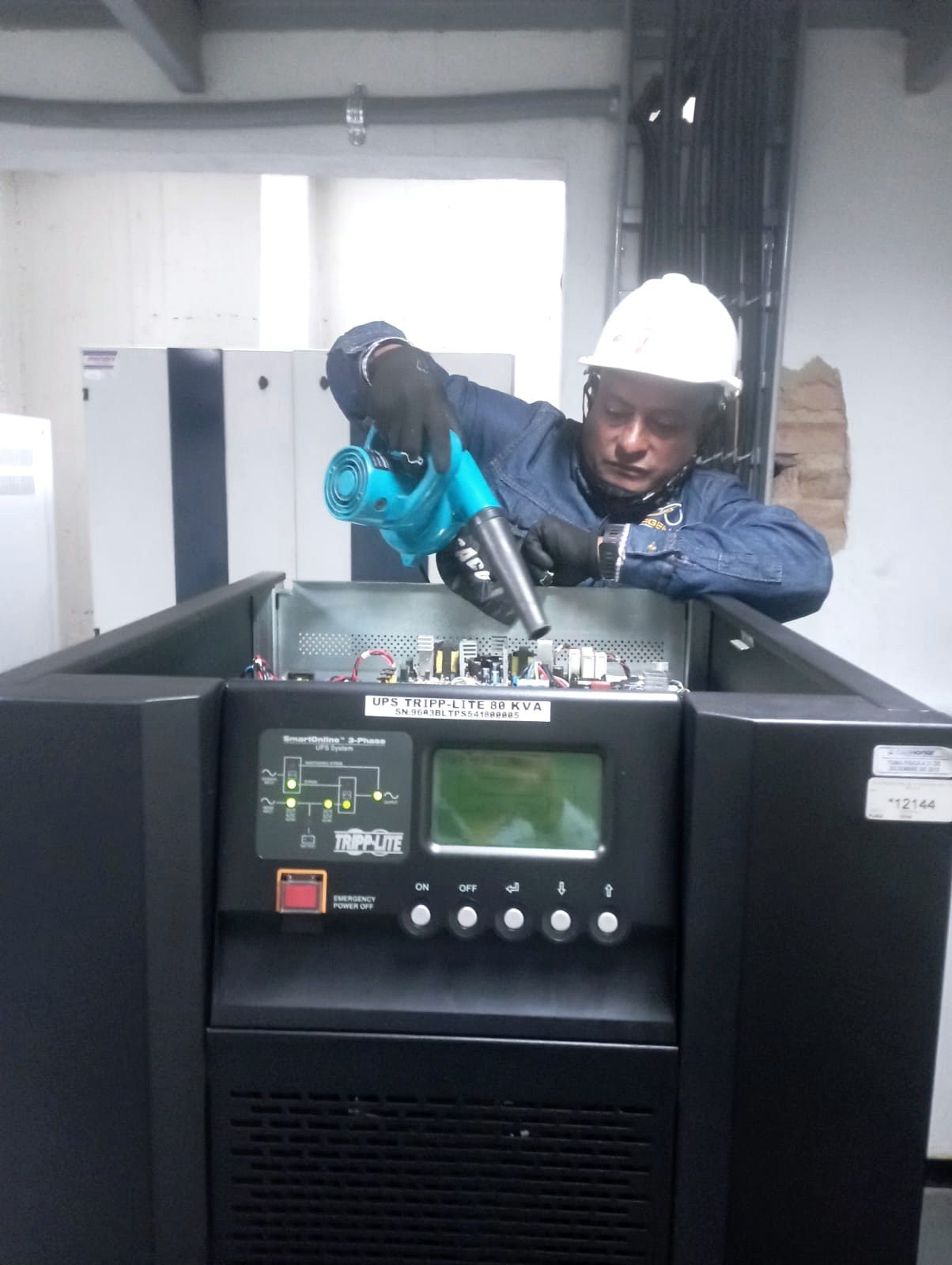 Técnico de SERGEMAQ con UPS trifásica abierta en mantenimiento